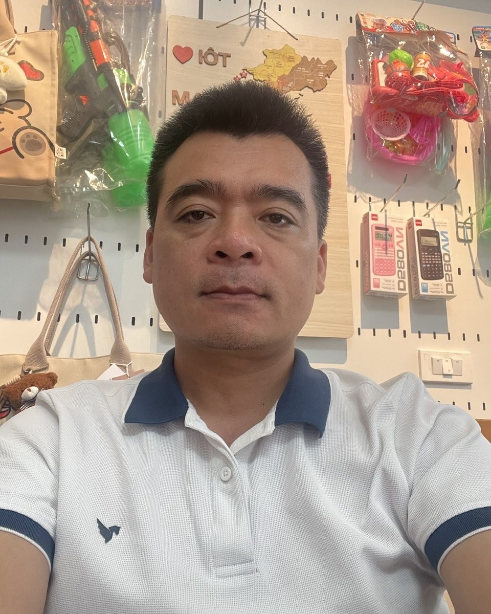 Anh Nguyễn Hữu Hảo, chủ cửa hàng Phong Linh, mặc áo polo trắng, chụp tại cửa hàng